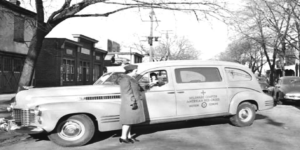 Red Cross Motor Corps Ann Naulty is shown standing by new ambulance in Wilmington Delaware 01-17-1942